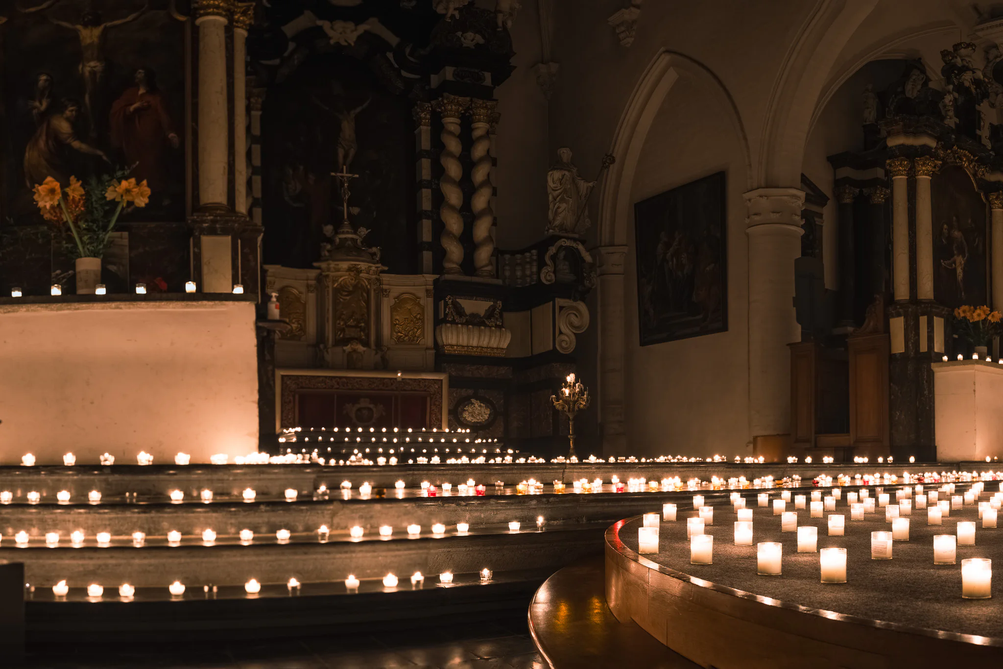 An oblique view across a chapel interior filled with rows of candles.